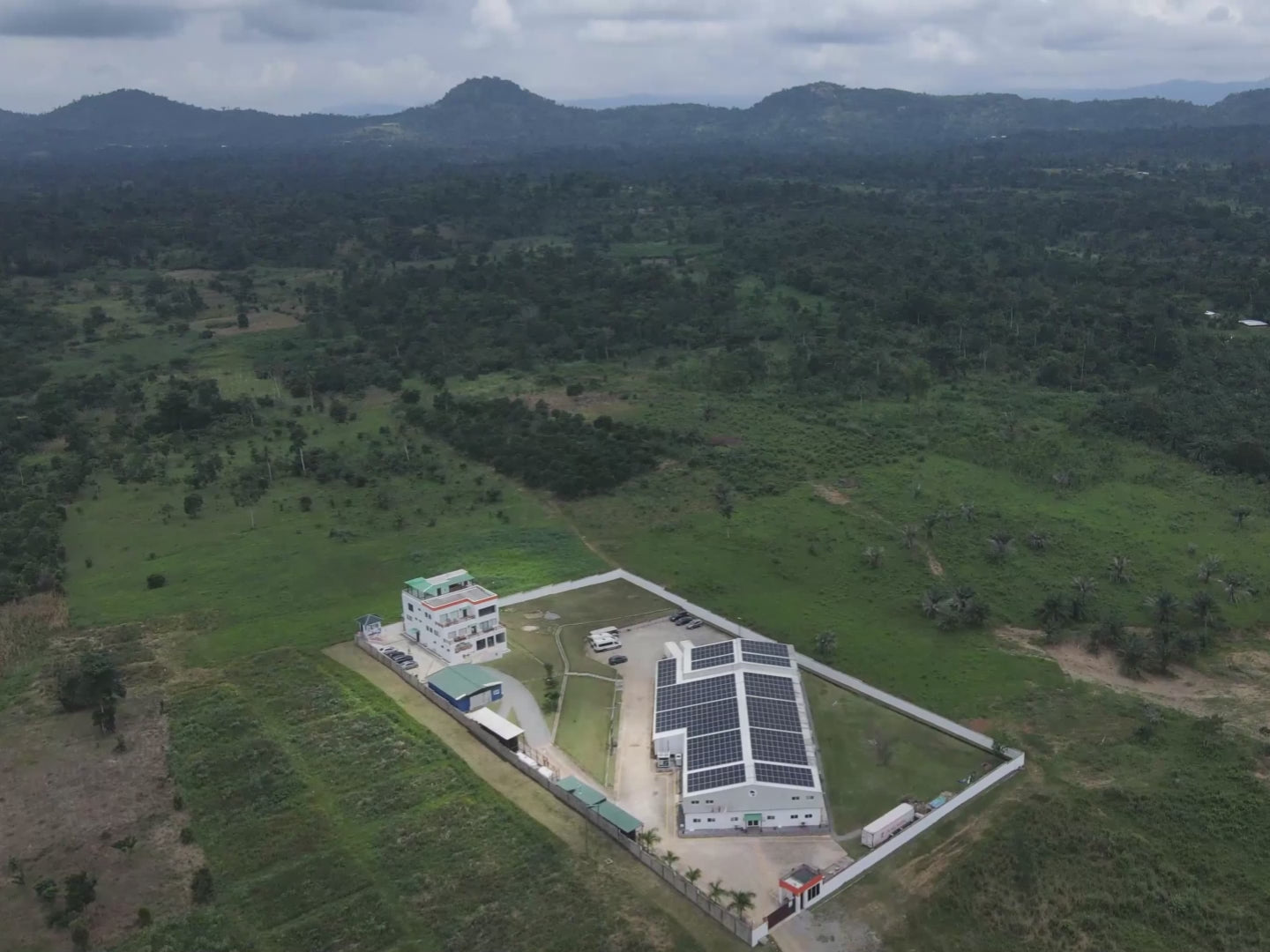 Aerial slow-motion footage of Zacao's solar-powered factory surrounded by lush Ghanaian jungle.